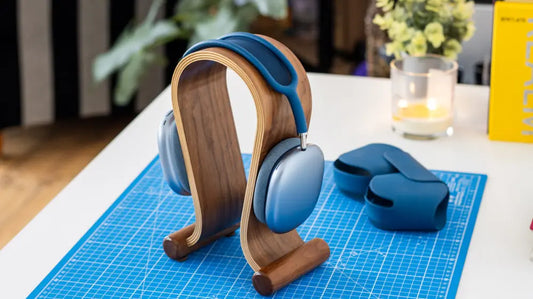 Cuffie AirPods Max Blue appoggiate su un supporto in legno su una scrivania con sfondo sfocato