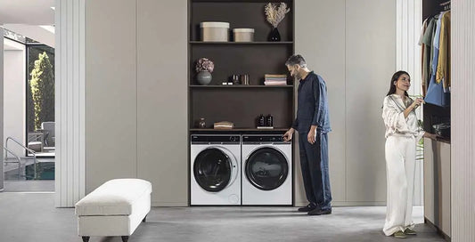 Coppia che utilizza lavatrice e asciugatrice in ambiente domestico con tecnologia nelle lavatrici moderne