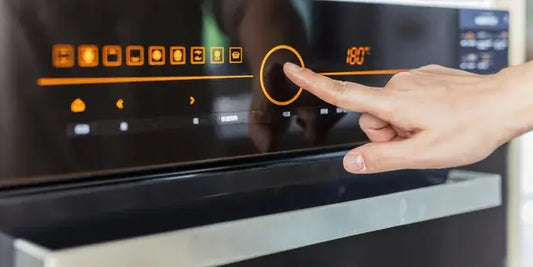 Persona che usa il pannello touch di un forno moderno con display digitale forni smart risparmio energetico
