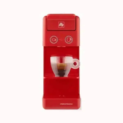 Macchina da caffè Illy rossa compatta con tazza di caffè espresso trasparente