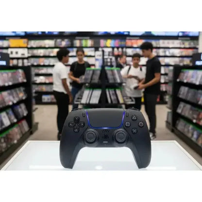 Controller SONY PS5 in primo piano con giochi sullo sfondo in un negozio di videogiochi